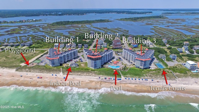 birds eye view of property featuring a beach view and a water view