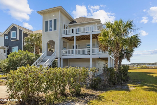 view of front of home with a balcony and a front yard