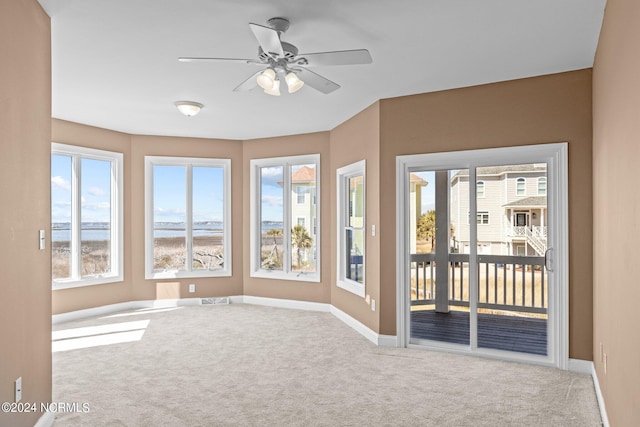 carpeted spare room featuring ceiling fan