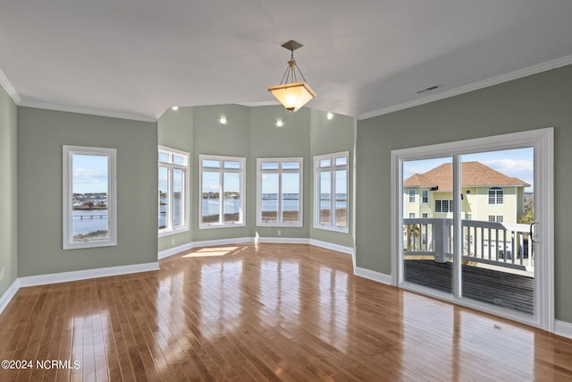 unfurnished room featuring a water view, a healthy amount of sunlight, light wood-type flooring, and crown molding