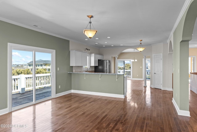 kitchen featuring hanging light fixtures, a healthy amount of sunlight, and white cabinetry