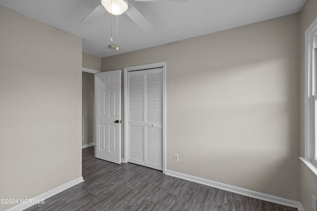 unfurnished bedroom with a closet, ceiling fan, and dark wood-type flooring