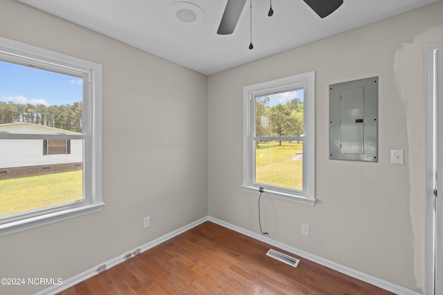 unfurnished room with hardwood / wood-style flooring, plenty of natural light, and ceiling fan