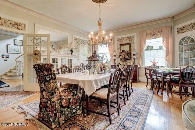 dining space featuring an inviting chandelier, light hardwood / wood-style floors, and ornamental molding