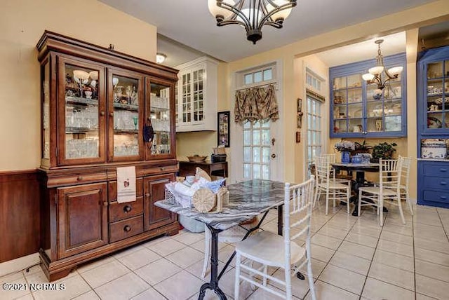 dining space with a chandelier and light tile floors