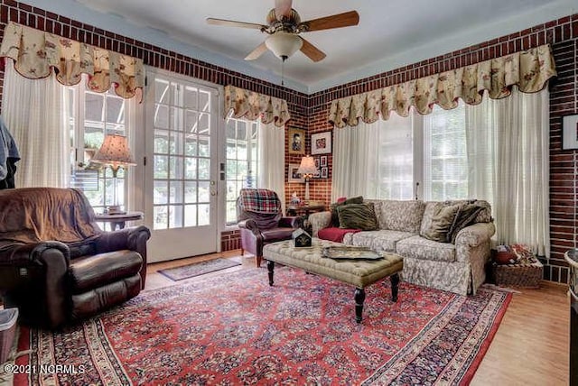 living room featuring ceiling fan, french doors, a wealth of natural light, and wood-type flooring