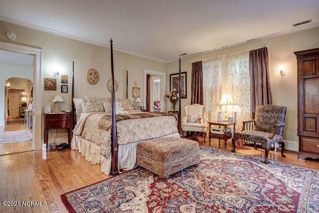 bedroom featuring crown molding and light hardwood / wood-style floors