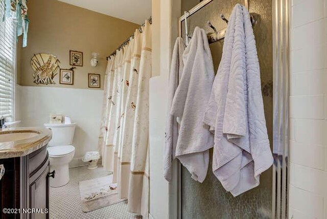 bathroom featuring vanity, toilet, and tile floors