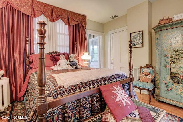 bedroom featuring radiator and light hardwood / wood-style flooring