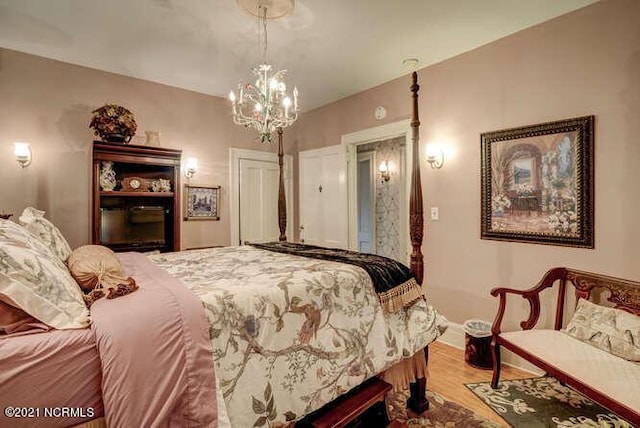 bedroom with an inviting chandelier and light hardwood / wood-style flooring