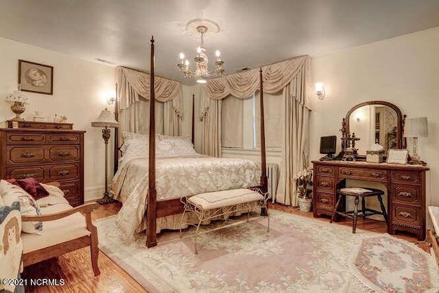 bedroom with a chandelier and light hardwood / wood-style flooring