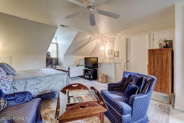 carpeted bedroom with ceiling fan and vaulted ceiling
