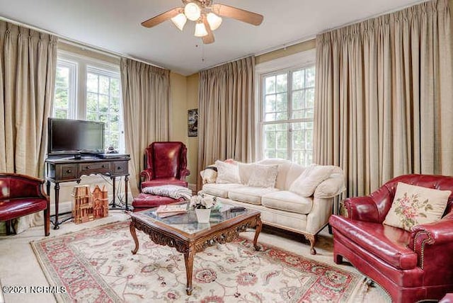 living room featuring ceiling fan and a wealth of natural light