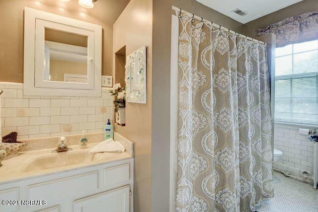 bathroom featuring tile floors, large vanity, and tile walls