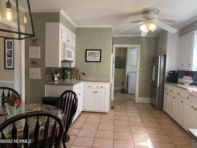 101 Spruce St, Washington, NC 27889 - kitchen featuring freestanding refrigerator, white microwave, washer / clothes dryer, backsplash, and a ceiling fan