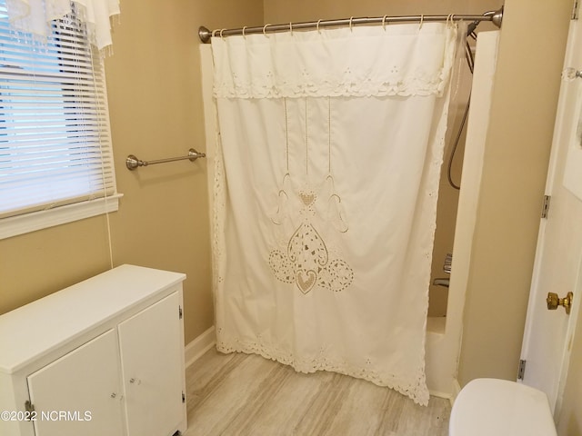 bathroom with toilet and hardwood / wood-style floors