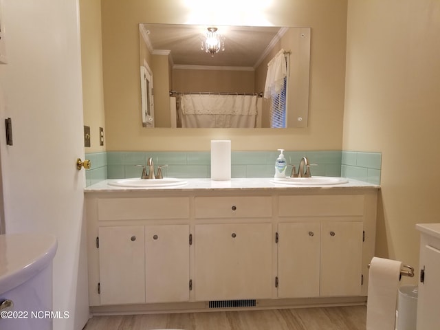 bathroom featuring double vanity, ornamental molding, and hardwood / wood-style floors