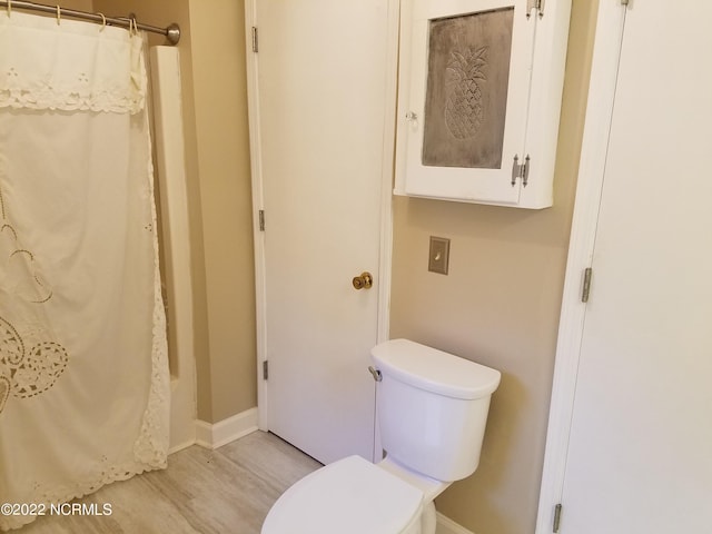 bathroom with toilet and hardwood / wood-style flooring