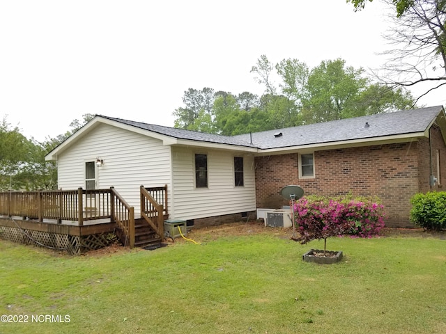 back of house with a wooden deck and a lawn