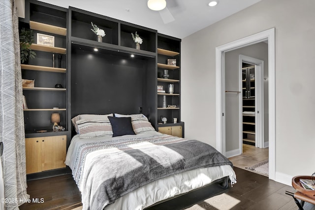 bedroom featuring a ceiling fan, baseboards, and dark wood finished floors