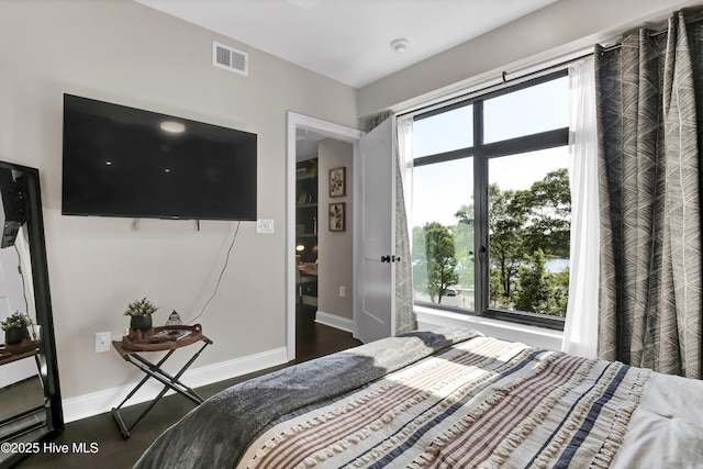bedroom featuring baseboards, visible vents, and multiple windows