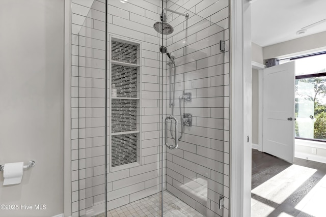 full bath with baseboards, a shower stall, and wood finished floors