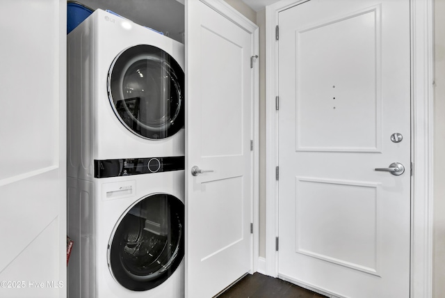 washroom with dark wood finished floors, laundry area, and stacked washer and dryer