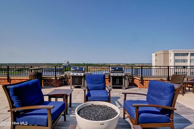 view of patio featuring a fire pit, a wooden deck, and area for grilling