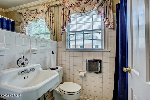 bathroom featuring tile walls, toilet, plenty of natural light, and sink