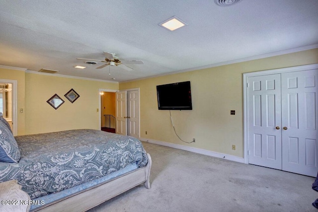 carpeted bedroom with ceiling fan, crown molding, and a textured ceiling