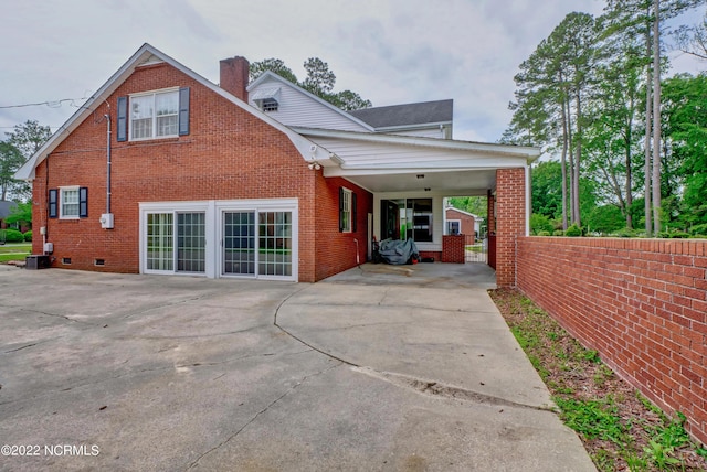 back of house featuring central AC unit and a carport