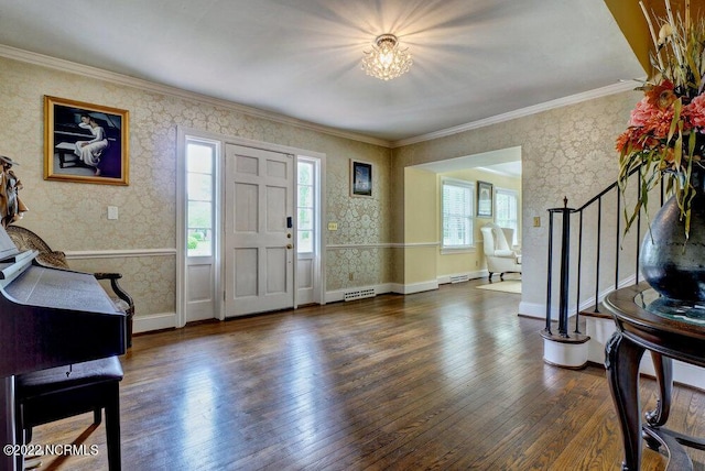 foyer featuring an inviting chandelier, ornamental molding, and dark hardwood / wood-style floors