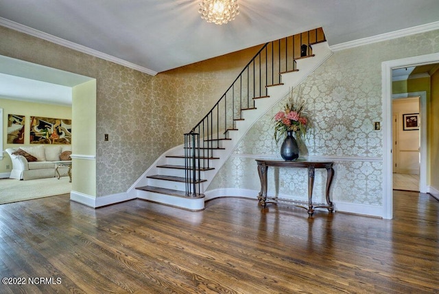 stairway with crown molding, dark wood-type flooring, and a chandelier