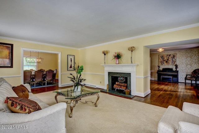 living room featuring ornamental molding, a notable chandelier, dark wood-type flooring, and baseboard heating