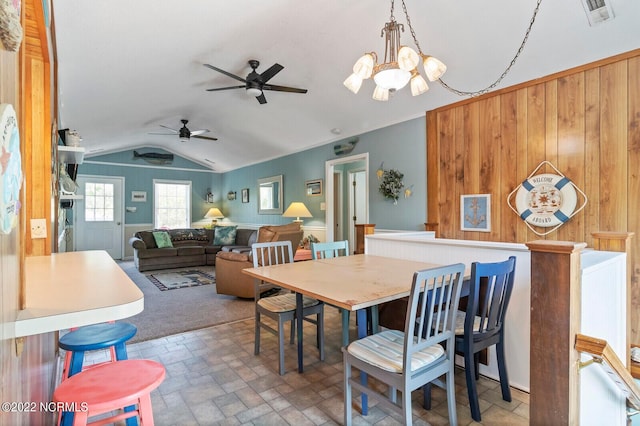 dining space featuring lofted ceiling, carpet floors, and ceiling fan with notable chandelier