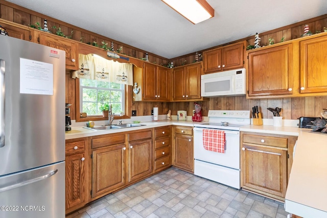 kitchen featuring white appliances, sink, and light tile flooring