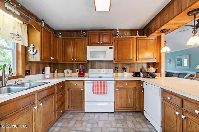 kitchen with tile flooring, sink, white appliances, and decorative light fixtures