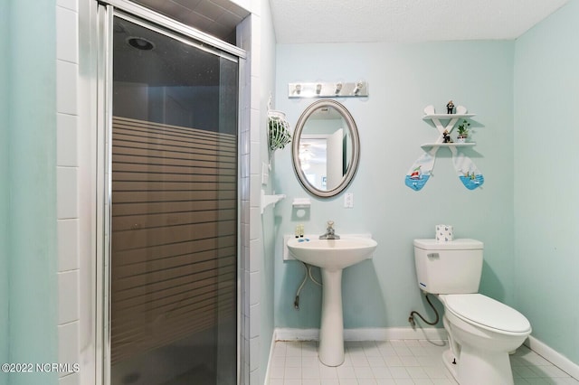 bathroom with tile flooring, a textured ceiling, a shower with shower door, and toilet