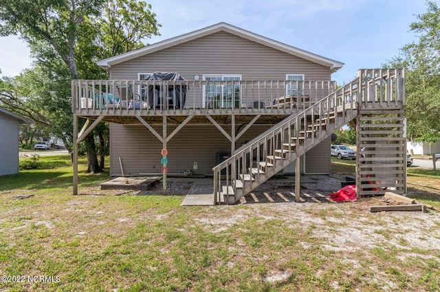 back of property with a deck and a lawn