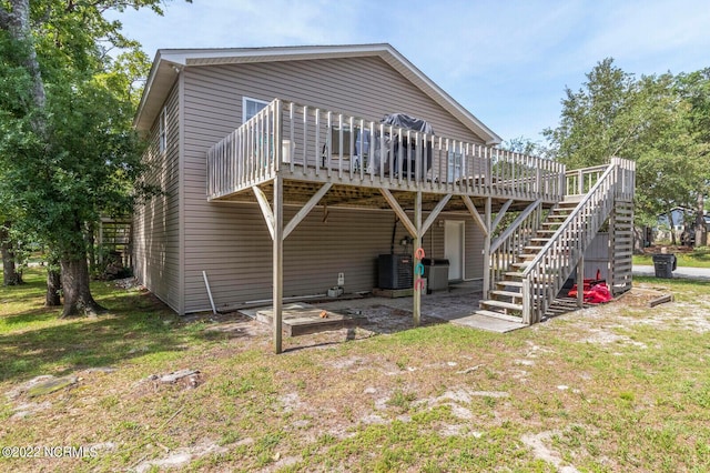 rear view of property with central air condition unit, a wooden deck, and a yard