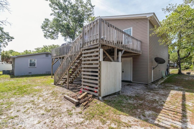 rear view of house featuring a deck and a yard