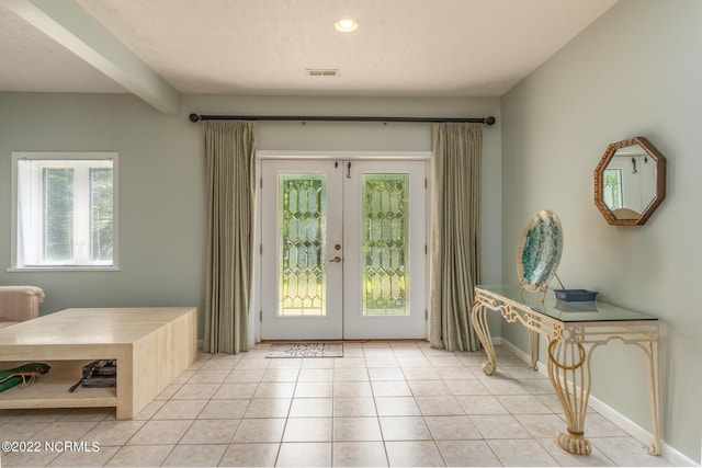 entryway featuring light tile floors and french doors