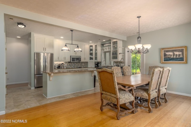 dining area with an inviting chandelier and light tile floors