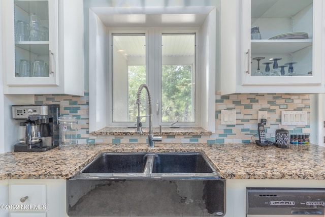 kitchen featuring white cabinetry, sink, backsplash, dishwasher, and light stone counters