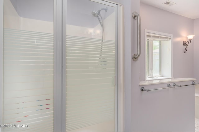 bathroom featuring tiled shower and vanity