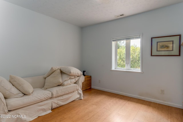 living area featuring a textured ceiling and light wood-type flooring