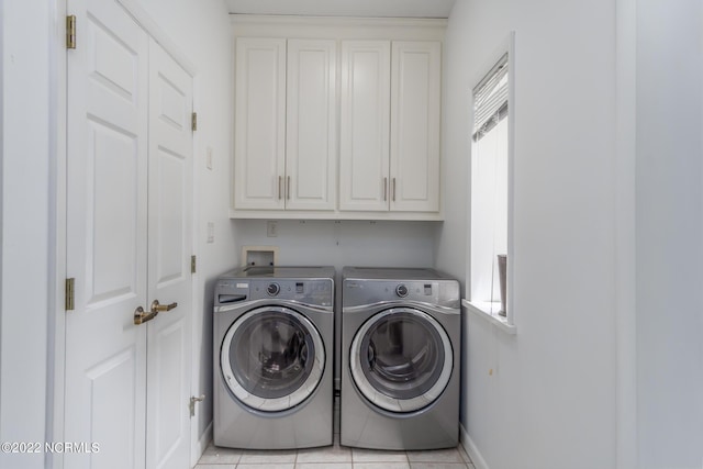 washroom featuring washing machine and dryer, cabinets, washer hookup, and light tile floors