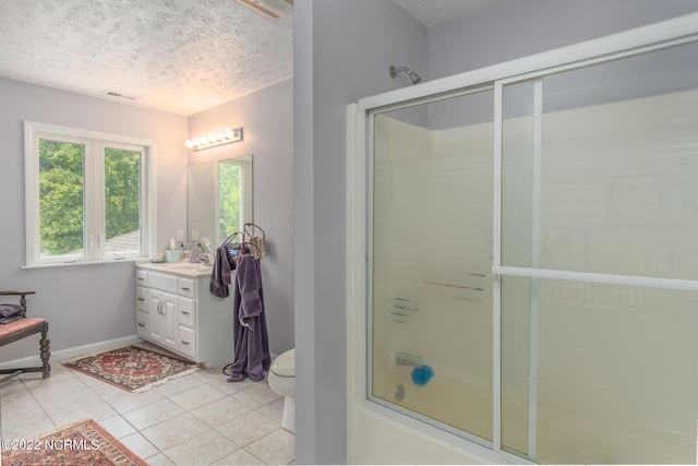 bathroom with a textured ceiling, tile floors, large vanity, and toilet