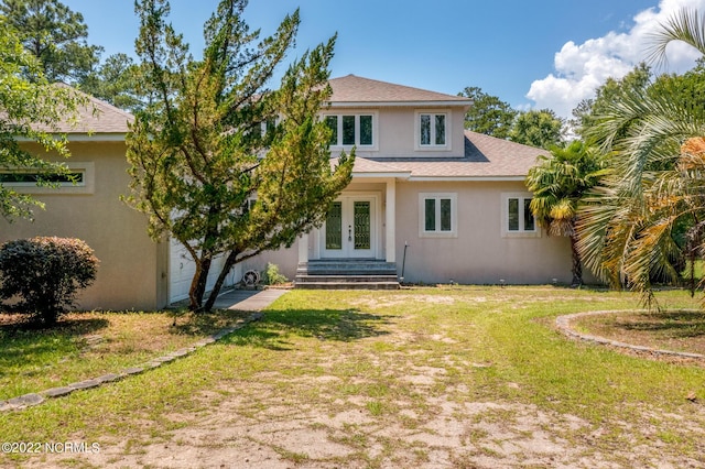 rear view of house with french doors and a yard