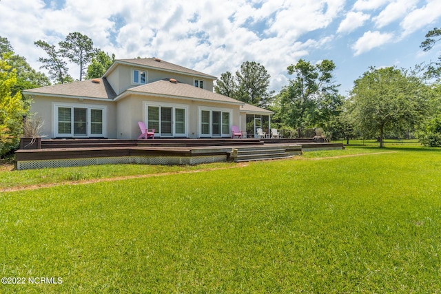 back of property with a wooden deck and a yard